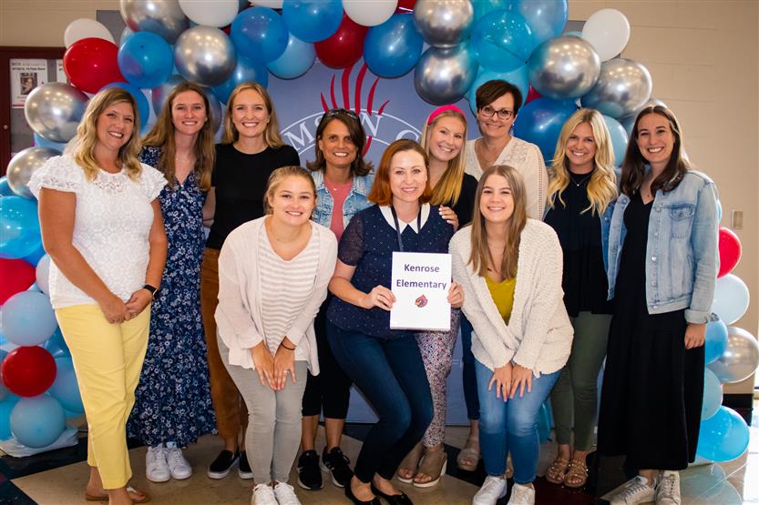 A group of teachers smile